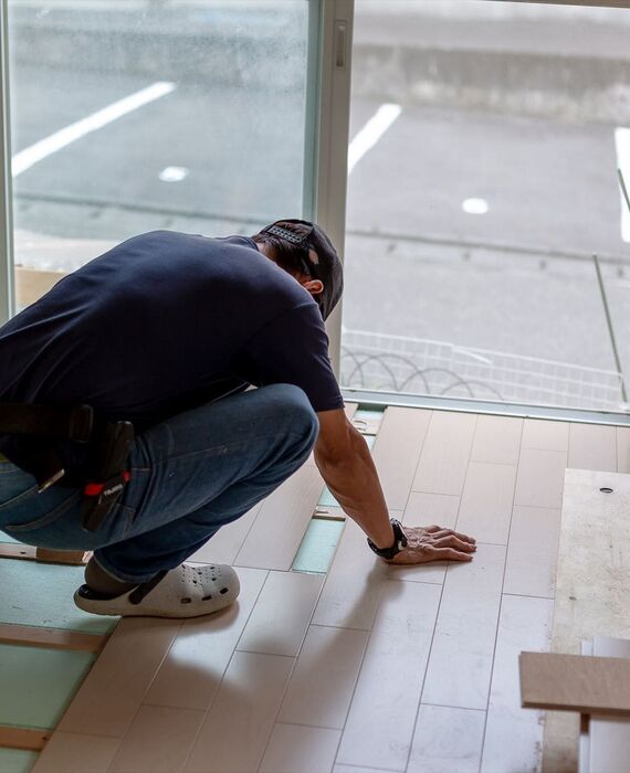 フローリングの貼り付け作業を行うスタッフ